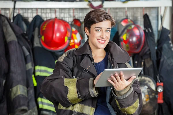 Happy Firewoman Holding Digital Tablet At Fire Station