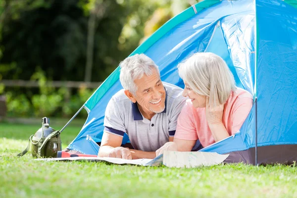 Senior Couple Studying Map In Tent At Park