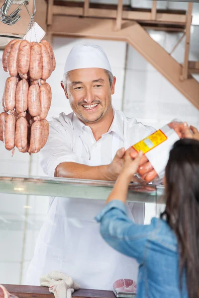 Man Giving Packed Sausages To Female Customer