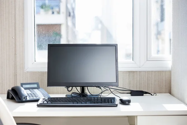 Computer And Landline Phone On Desk