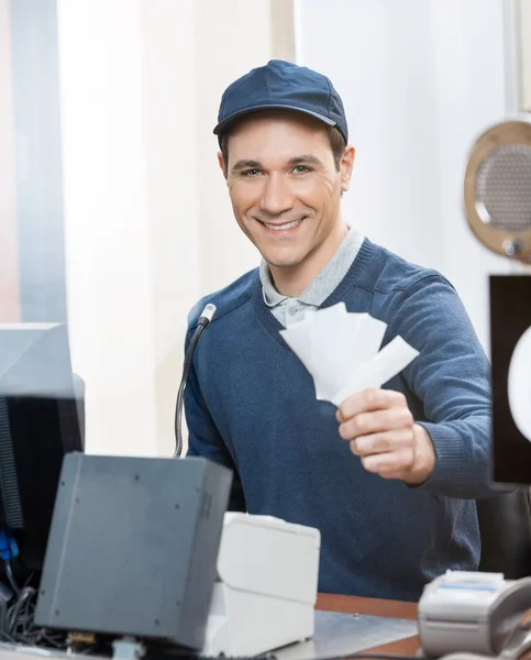 Worker Holding Tickets At Box Office Counter