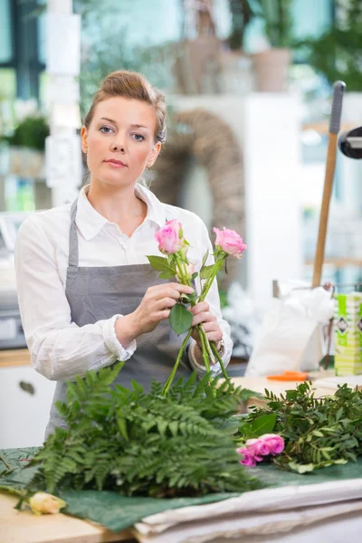 Florist Making Rose Bouquet In Flower Shop