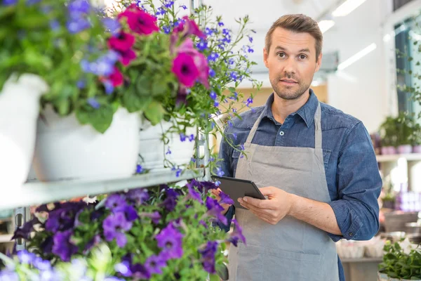 Confident Worker Using Digital Tablet In Flower Shop