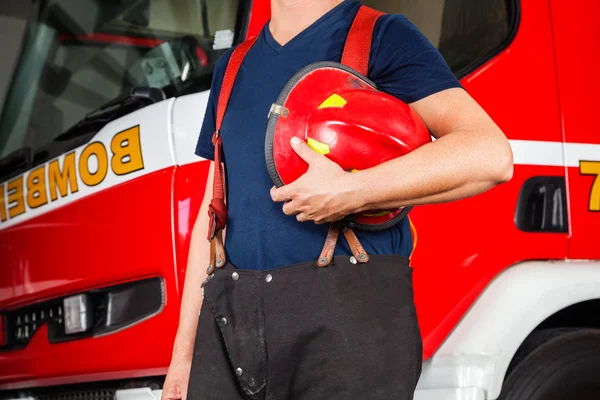 Midsection Of Fireman Holding Red Helmet