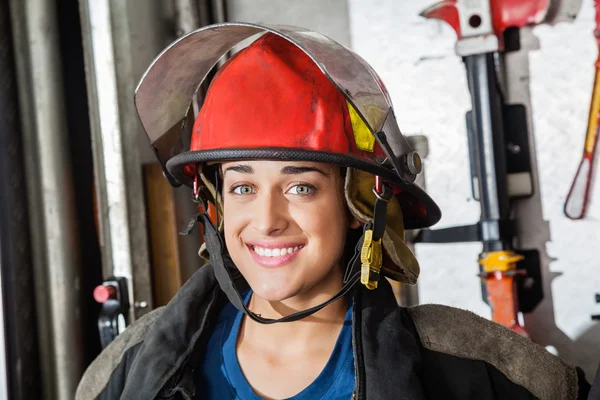 Happy Female Firefighter At Fire Station