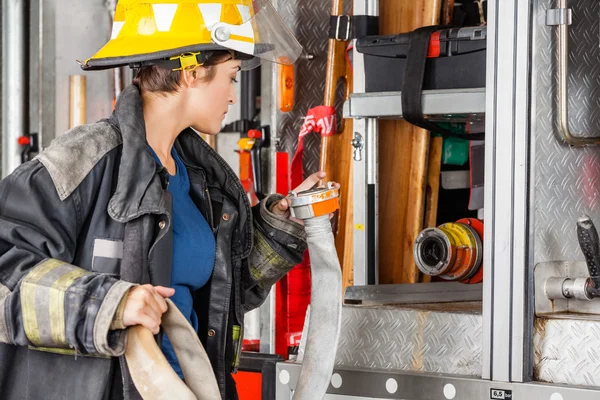 Firefighter Examining Water Hose By Truck