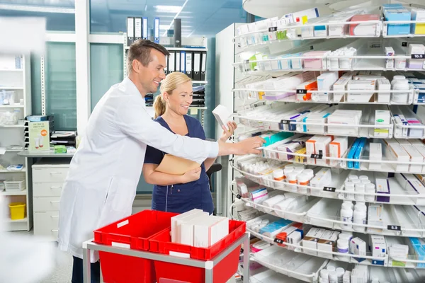 Happy Pharmacist And Assistant Counting Stock In Pharmacy