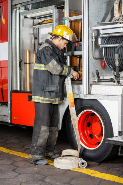 Firefighter Fixing Water Hose In Truck