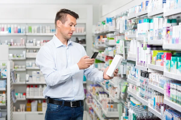 Male Customer Scanning Product Through Mobile Phone In Pharmacy