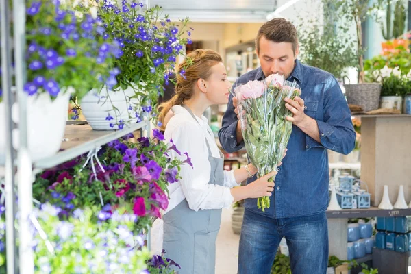 Florist And Customer Smelling Flower Bouquet At Store