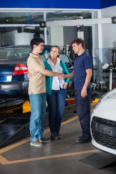 Mechanic Shaking Hand With Couple