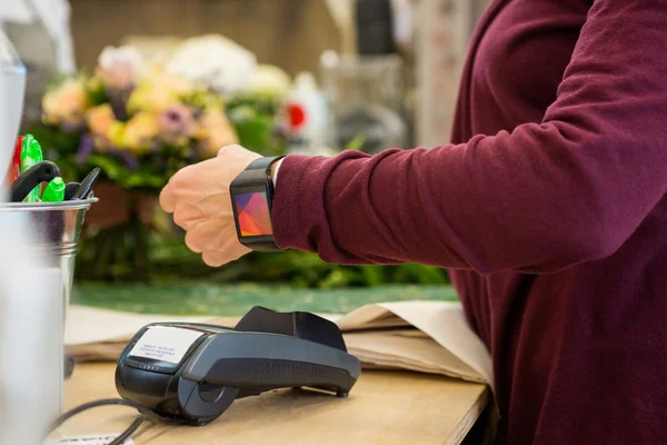 Customer Paying Through Smart Watch At Flower Shop