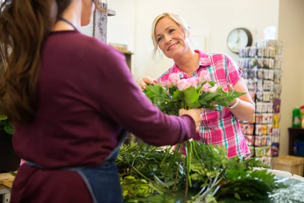 Woman Buying Bouquet Of Roses From Florist