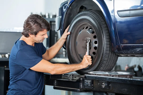 Mechanic Fixing Car Tire Wrench