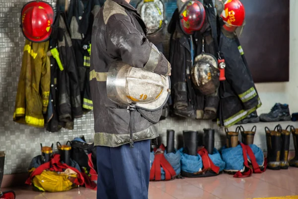 Fireman Holding Helmet At Fire Station