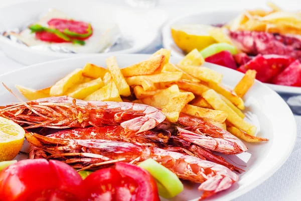 Grilled prawns with a side of fries and fresh veggies (shallow dof)