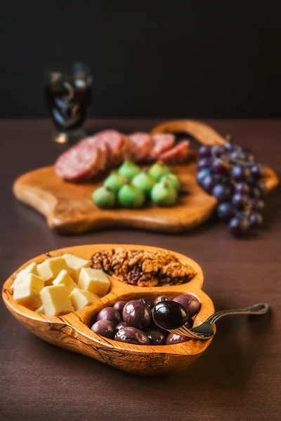 Cured sausage, figs, grapes, cheese, walnuts and olives served with red wine )selective focus)