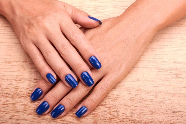 Woman hands with blue manicure and nail polish