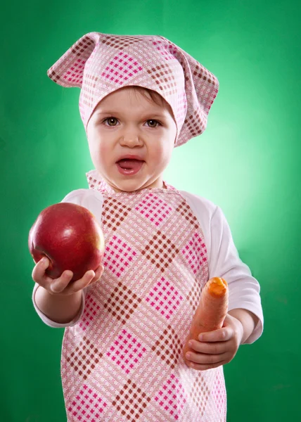 The baby girl with a kerchief and kitchen apron holding an vegetable isolated