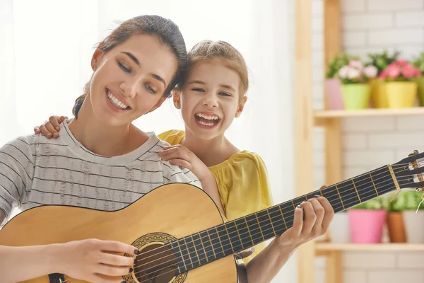 Mother and daughter playing guitar