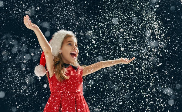 Little girl catching snowflakes