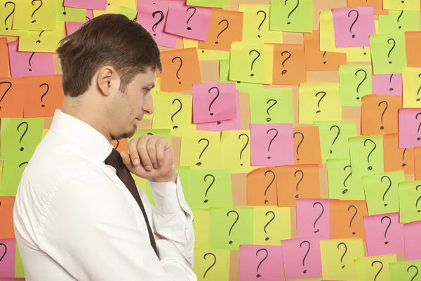 Businessman thinking with question marks written