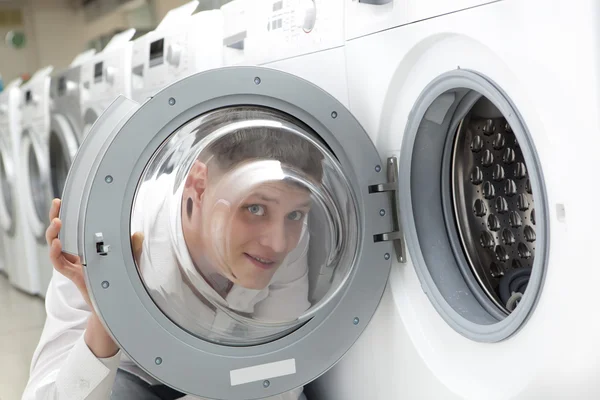 Young man buying new washing machine