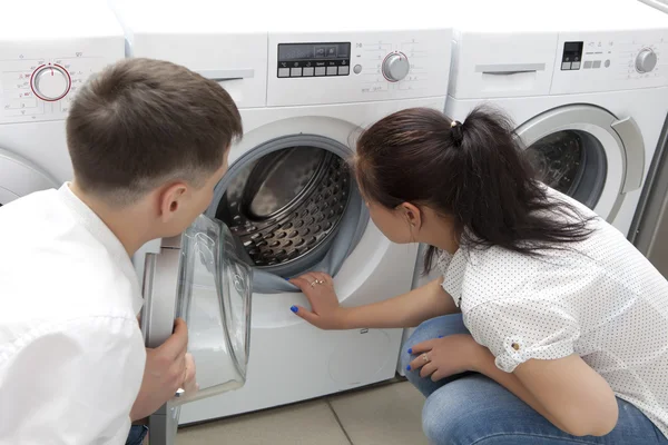 Happy family couple buying new washing machine