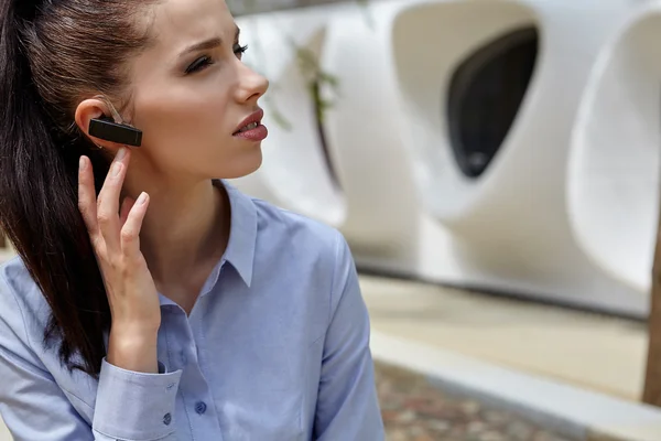 Businesswoman working with Bluetooth headset