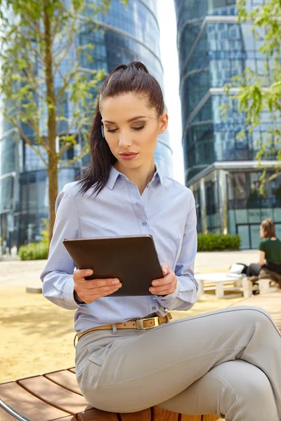 Woman drinking coffee and reading tablet