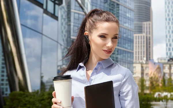 Woman drinking coffee and reading tablet