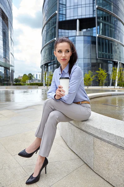 Businesswoman with disposable coffee cup