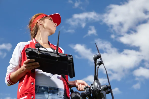 Woman with remote control and flying surveillance drone