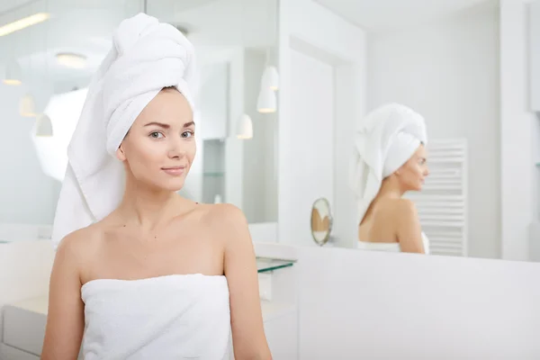 Woman wrapped in white towels