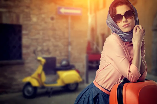 Woman with suitcase on street of italian city