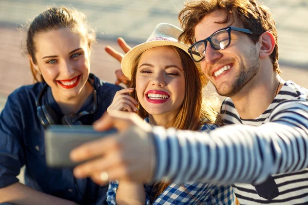 Smiling friends making selfie outdoors