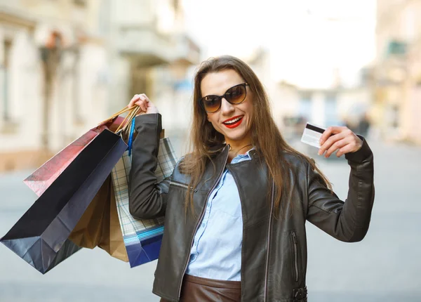 Beautiful woman with shopping bags and credit card in the hands