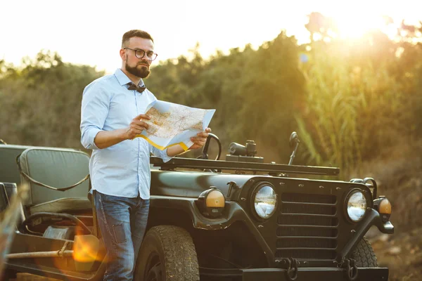 Young stylish man with glasses and bow tie see the map near the