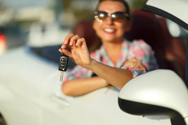 Woman sitting in a convertible car with the keys in hand - conce
