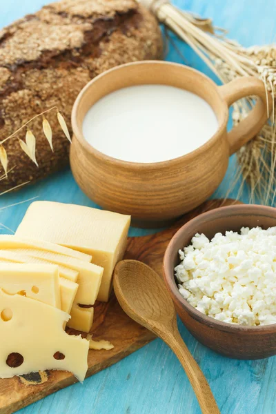 Cottage cheese, milk, bread and cheese on a wooden background
