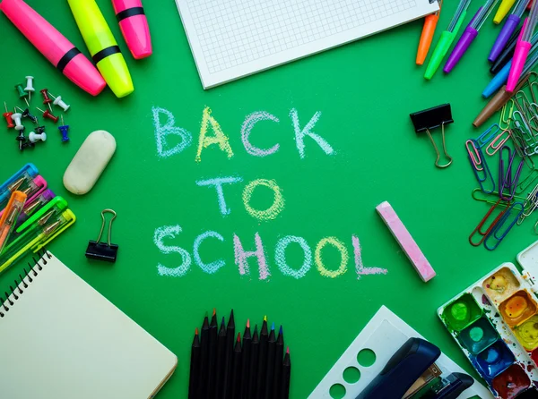 School supplies on blackboard background ready for your design