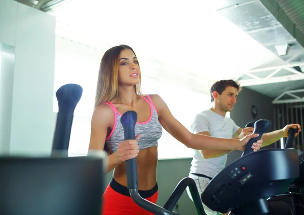 Athletic man and woman doing cardio training program in fitness