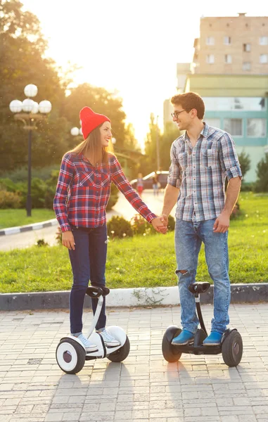 A young couple riding hoverboard - electrical scooter, personal