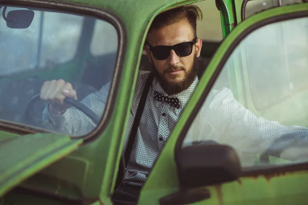 Young stylish handsome man, wearing shirt and sunglasses, drivin