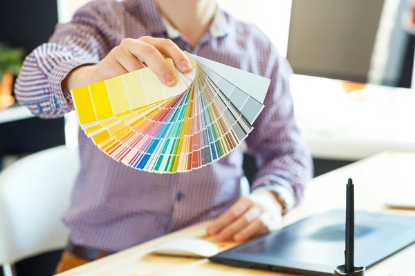 Young man looking to a color paint palette