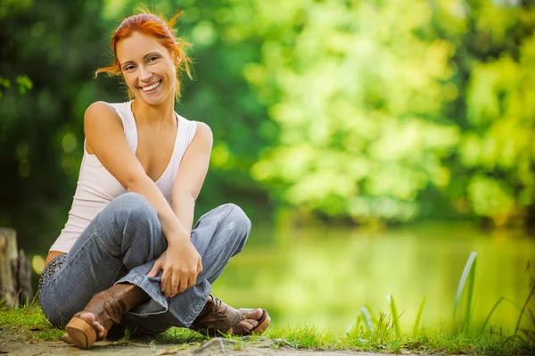 Smiling beautiful woman sitting on ground