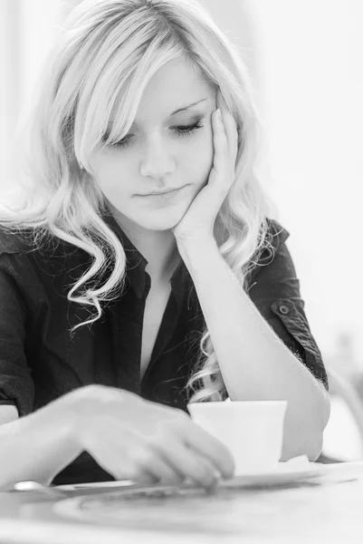Young beautiful woman sits in cafe