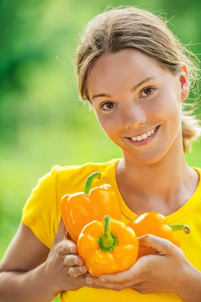 Young woman in yellow blouse with bell pepper