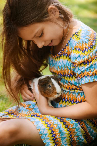 Little girl petting guinea pig