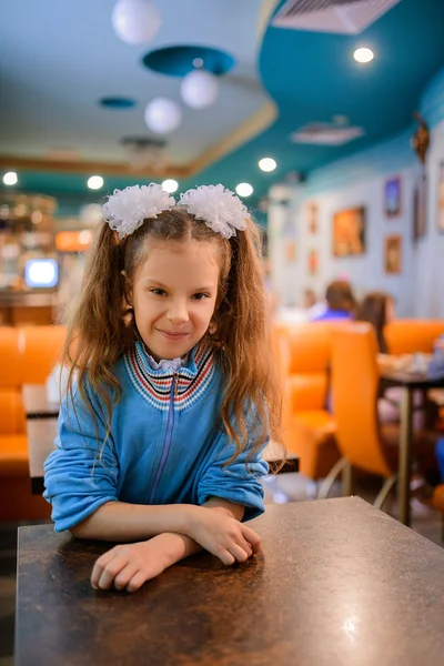 Little beautiful cheerful girl in restaurant
